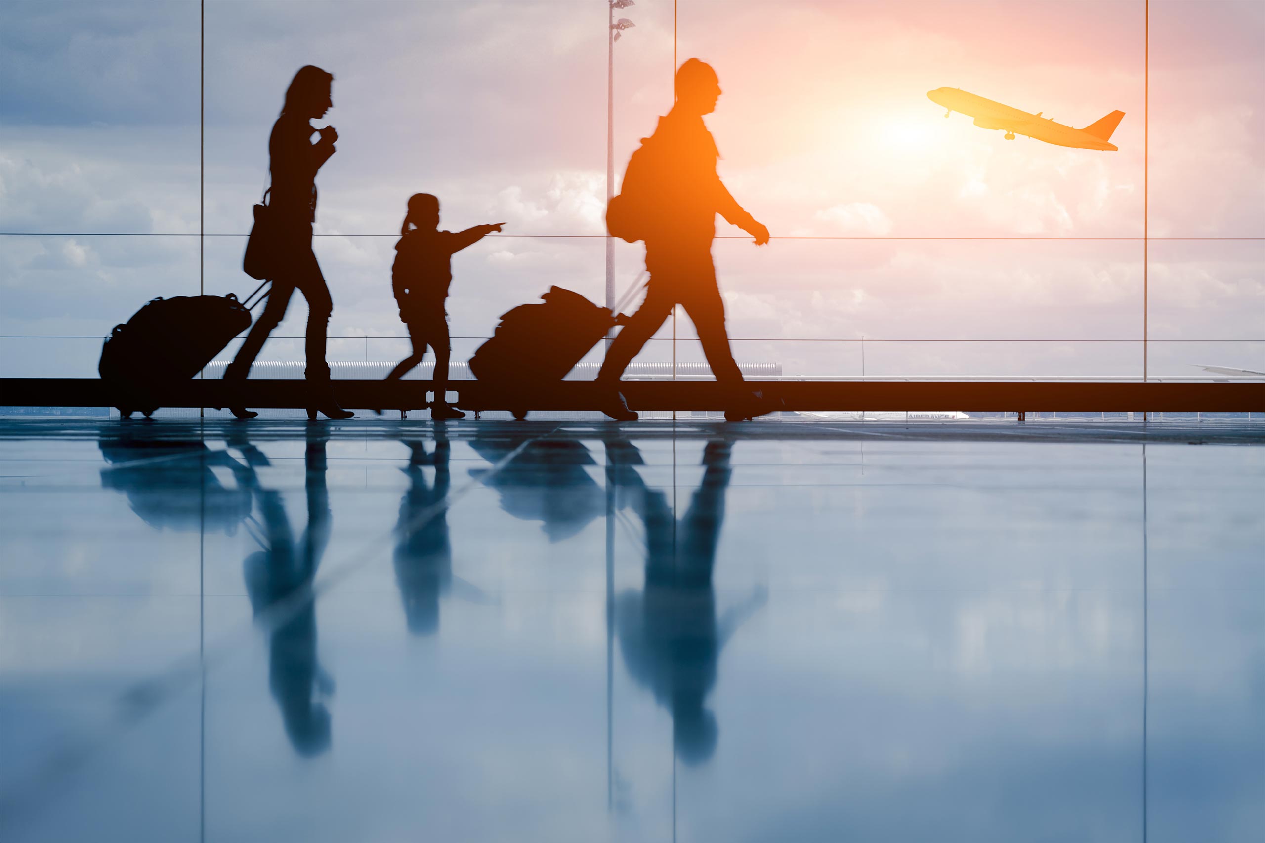 Familie mit Urlaubsgepäck auf dem Weg zum Flieger